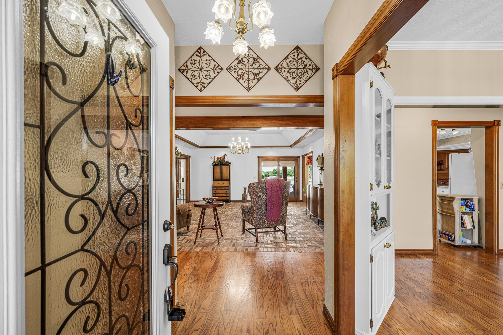 Front entry with a decorative wrought iron and glass door looking into the formal living area beyond