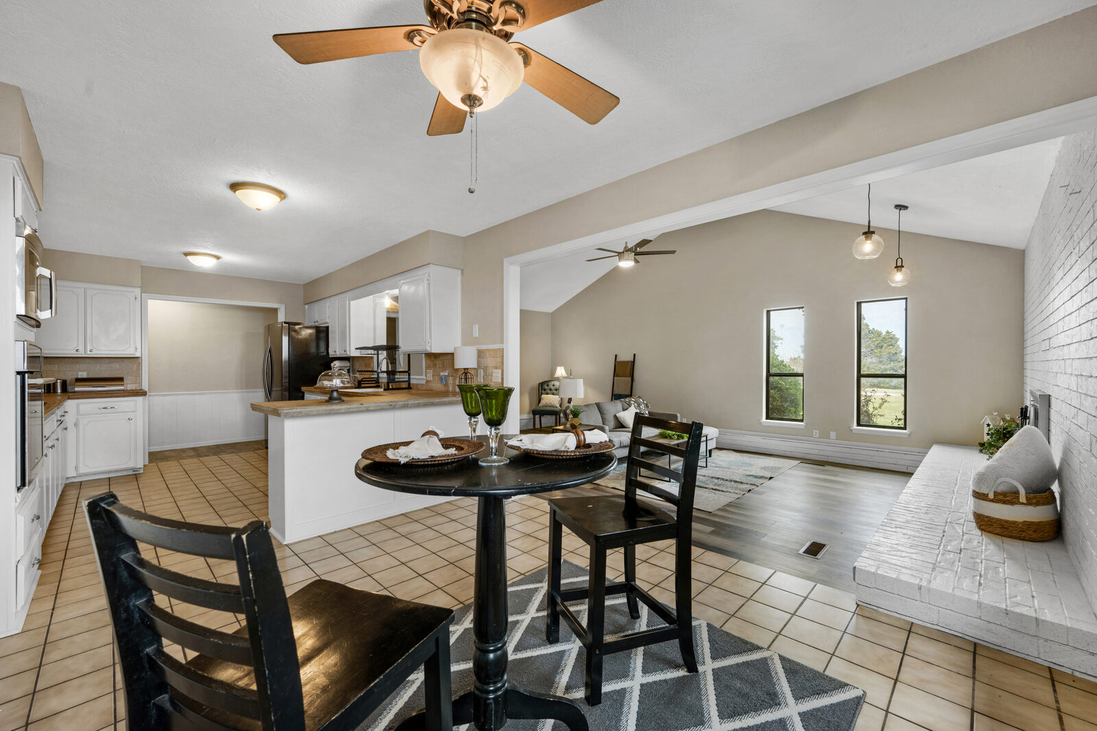 Open layout view from the kitchen and dining area across to the sunken living room — original split-level floor plan refreshed with new flooring, paint, and fixtures