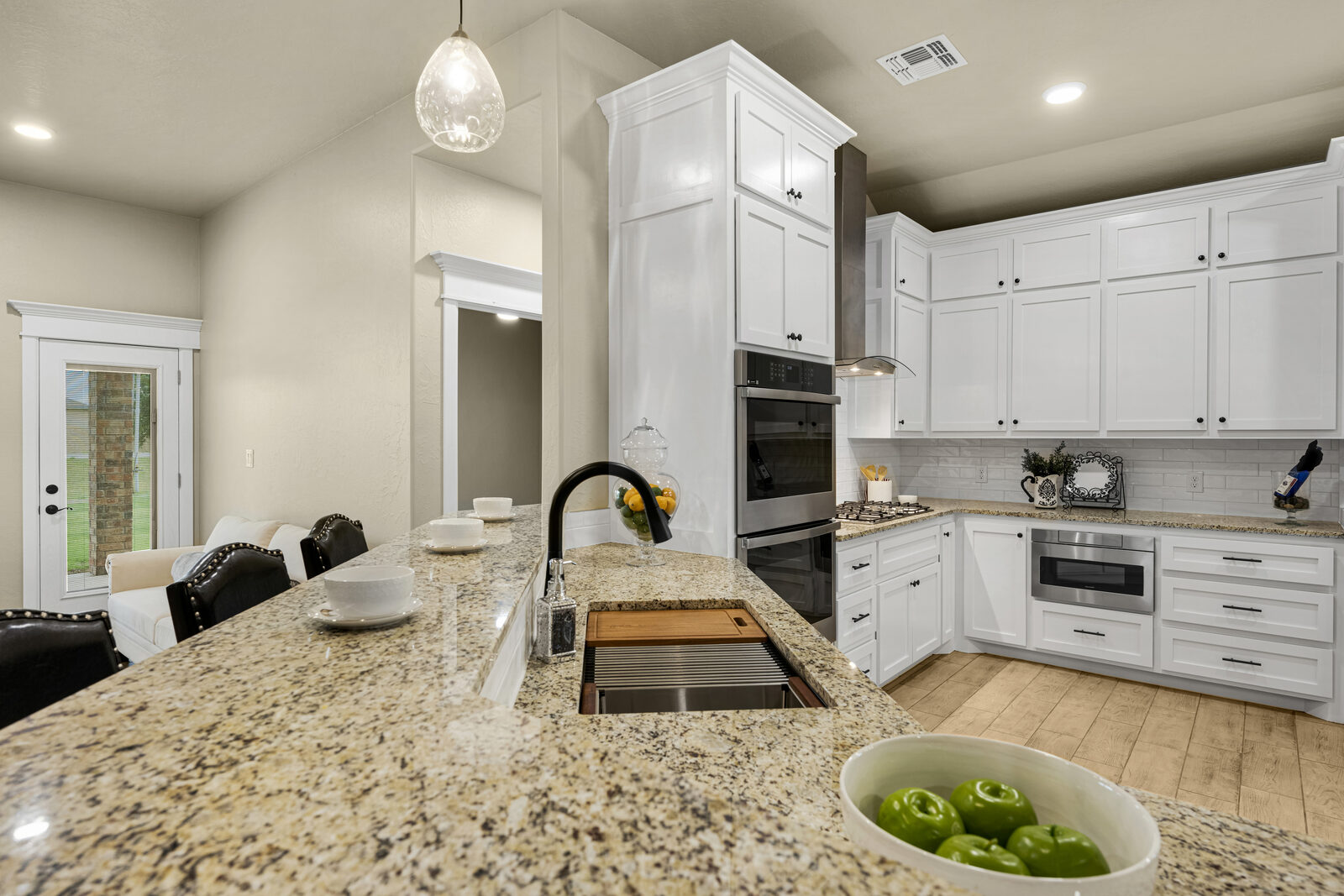 Kitchen from an alternate angle — gas cooktop with stainless chimney range hood, subway tile backsplash, microwave drawer